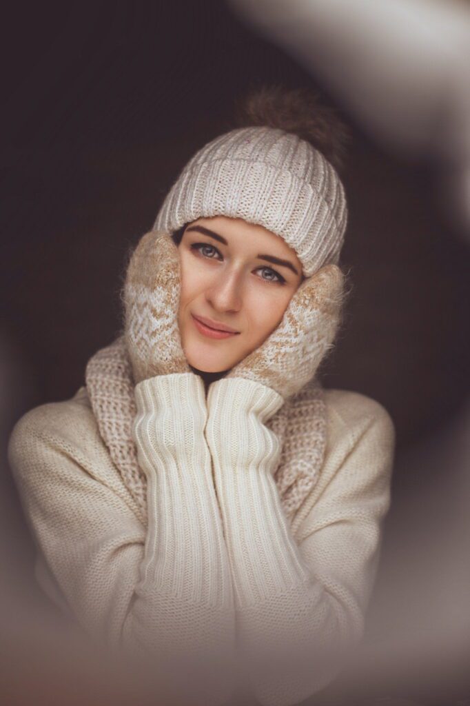 Woman in white sweater and winter hat.