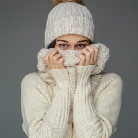 Woman in white sweater and winter hat.