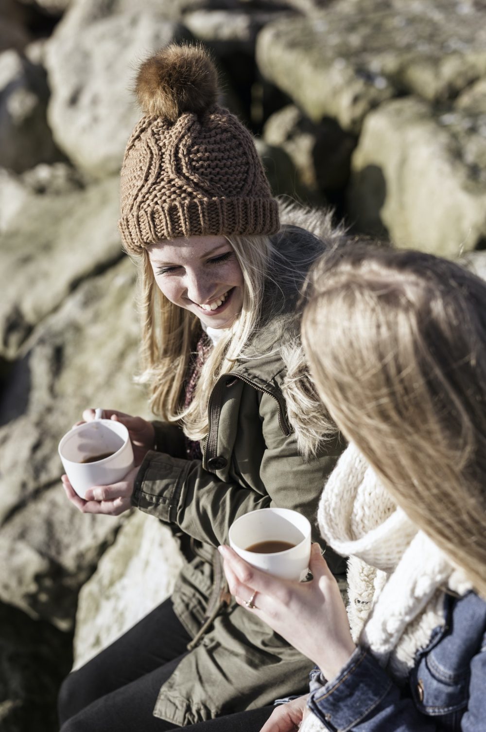 Two girls having a winter picnic on the beach.